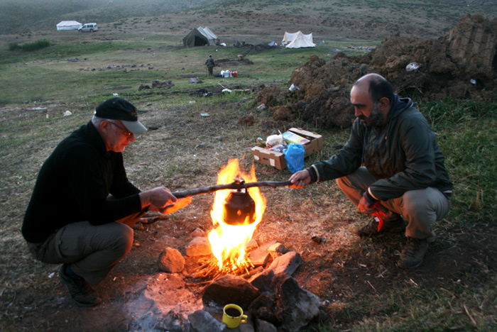 Yönetmen Çayan Demirel ile gazeteci Ertuğrul Mavioğlu, Bakur belgeseli için çıktıkları dağlarda, çoban ateşinde çay için su ısıtıyor. Demirel, belgeselin çekimi bittikten sonra kalp krizi geçirdi