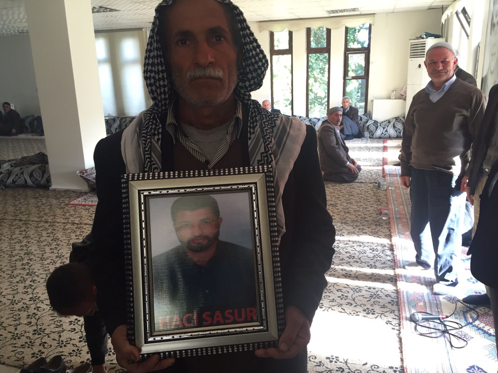 Pazartesi gecesi Tahir Elçi anması dağılırken patlayan bombada hayatını kaybeden Hacı Sasur'un fotoğrafıyla taziye evinde yas tutan babası 