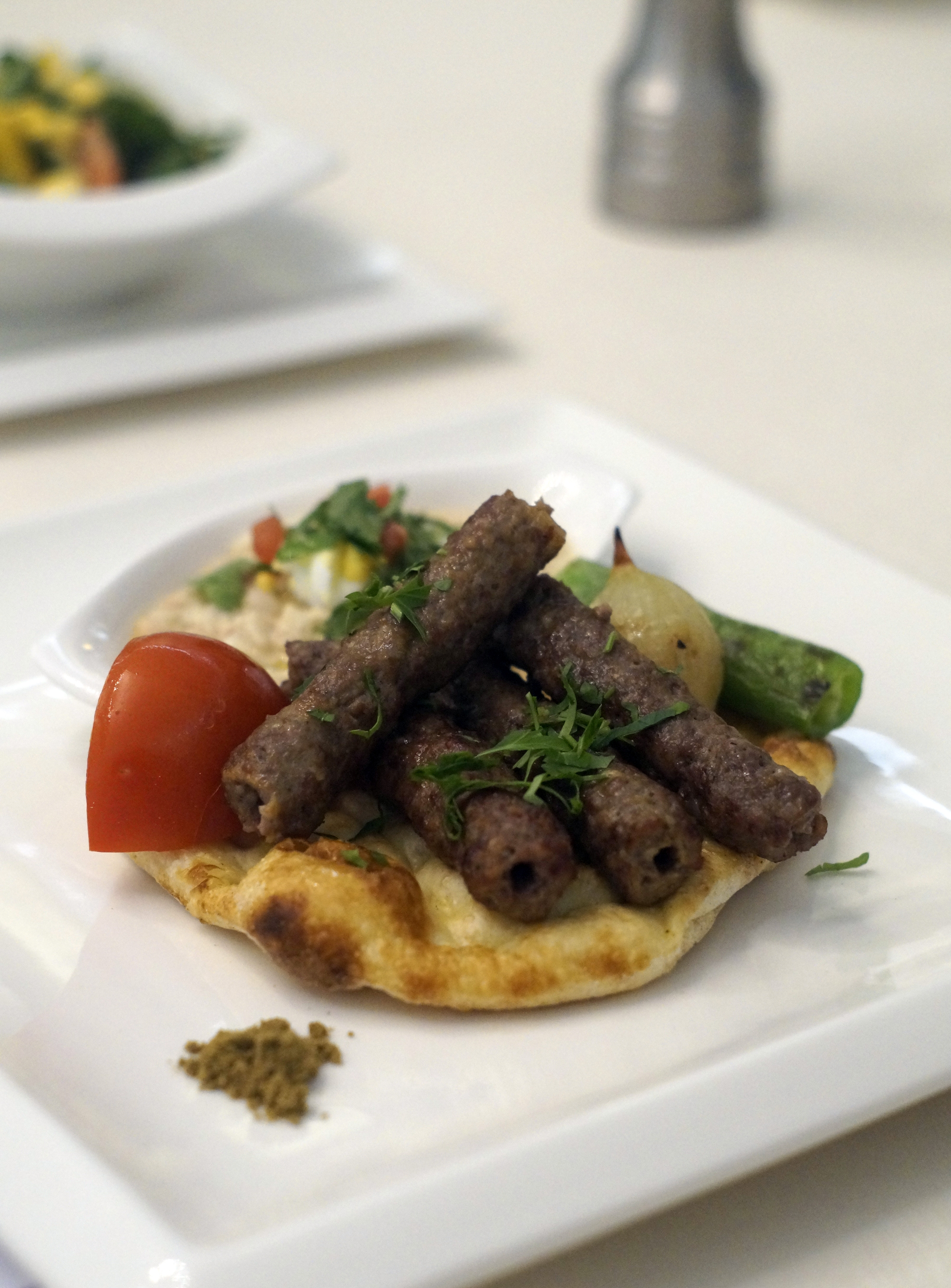 Tirmis Restaurant'ın en iddialı yemeği, tahinli Antalya piyazıyla sunulan Antalya şiş köftesi...
