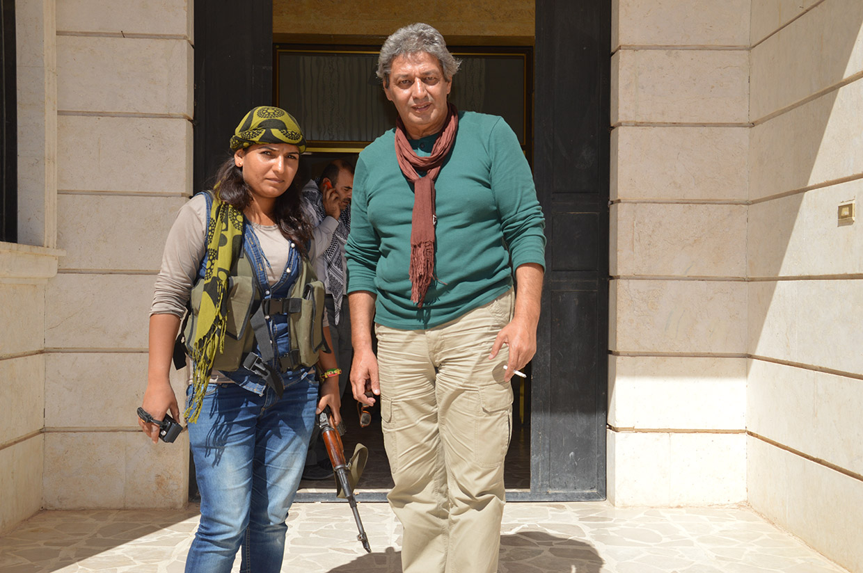 Havar Haber Ajansı Kobane Muhabiri Dicle'nin bir elinde kamera, diğer elinde kalaşnikof var
