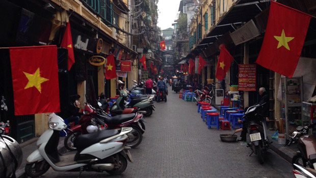 Hanoi'de başını nereye çevirsen, Komünist Partisi’nin orak çekiçli kızıl bayrakları ve Vietnam’ın kızıl üstüne ortasında sarı yıldızlı milli bayrağı.