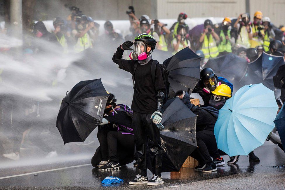 
                    Pro-democracy protesters react as police fire water cannon in Hong Kong in September. The protests started in June over a controversial extradition bill but evolved into broader anti-government demonstrations that have gripped the territory for more than six months.
                