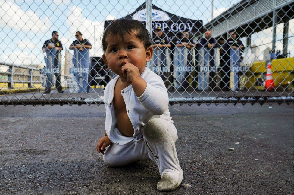 
                    A Mexican one-year-old awaiting her turn to seek asylum in the US with her mother is seen in front of the gates to the Gateway International Bridge in Matamoros.
                