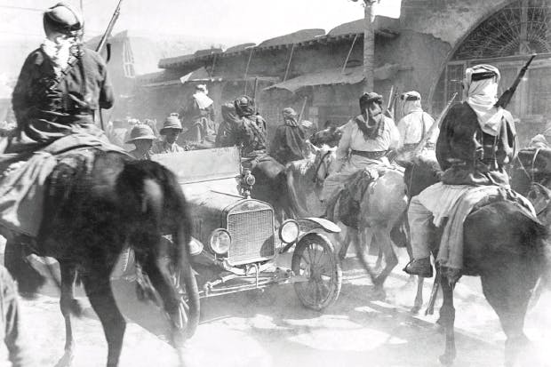 1582200101265-british-officers-in-a-modern-motor-car-drive-against-the-current-of-horsemen-of-the-arab-army-entering-damascus-on-1-october-1918.%20Anglo-Arab%20policies%20were%20equally%20at%20cross%20purposes%20following%20the%20fall%20of%20the%20city
