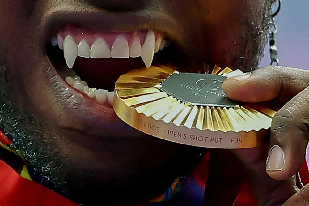 Altın madalya sahibi Kolombiyalı Mauricio Valencia, Paris 2024 Paralimpik Oyunları'nda, madalyasını podyumda ısırıyor. | 7 Eylül 2024, Ümit Bektaş