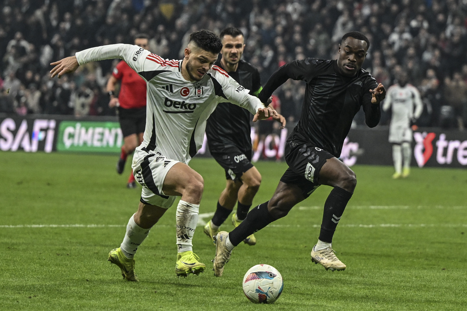 Cem Dizdar: Tribünden maçın ilk yarısına tanıklık eden Beşiktaş’ın yeni teknik direktörü Ole Gunnar Solskjaer içinden şunları geçirmiş olmalı: ‘Bu oyun ne benim oynadığım ne yönettiğim ne de izlediklerime benziyor!’ Koca devre boyunca amaçsızca sağa sola koşturan oyunculardan kurulu iki takımdan kendisinin yöneteceğini gördükçe kara kara düşüncelere dalmış olmalı yeni hoca. Devre boyunca 15. dakikada Ciro Immobile’nin direkten dönen şutu ile Beşiktaş savunma oyuncularının birbirlerine girmesi neticesinde önüne düşen topu ceza sahası dışından kaleye vuran Emre Kılınç’ın şutu dışında olan bitene ‘futbol’ demeye bin şahit gerekirdi. Öyle ki, zaman zaman kimi takım için derler ya, ‘Şut dahi atamadı.’ İşte o misal! Beşiktaş korner dahi kullanamadı devre boyu! Stadyumda izlemesi ızdırap olan bu maçı Beinsports için anlatan Ali Ferahbot’un ajite tarzı da olmasa muhtemelen insanlar televizyon karşısında uyuklardı! Nihayet 62. dakikada derli toplu sayılacak ilk Beşiktaş atağında Ferahbot uyuklayanları ‘dürttü’ ancak Rafa Silva topu kaleye ‘Dürtemedi! Transfer yasağı gibi ezberlenmiş bir olumsuzluk tabusuna rağmen Thomas Reis antrenmanlarının yüksek randımanıyla 22.5 milyon Euro piyasa değeri olan Samsun son bölüme kadar 77.5 milyon Euro piyasa değerli Beşiktaş’la kafa kafaya oynadı ve bir puanı almayı başardı. Elbette bunda zaman zaman Mert Günok performansına ulaşan Okan Kocuk’un da payı büyüktü. (Fanatik)