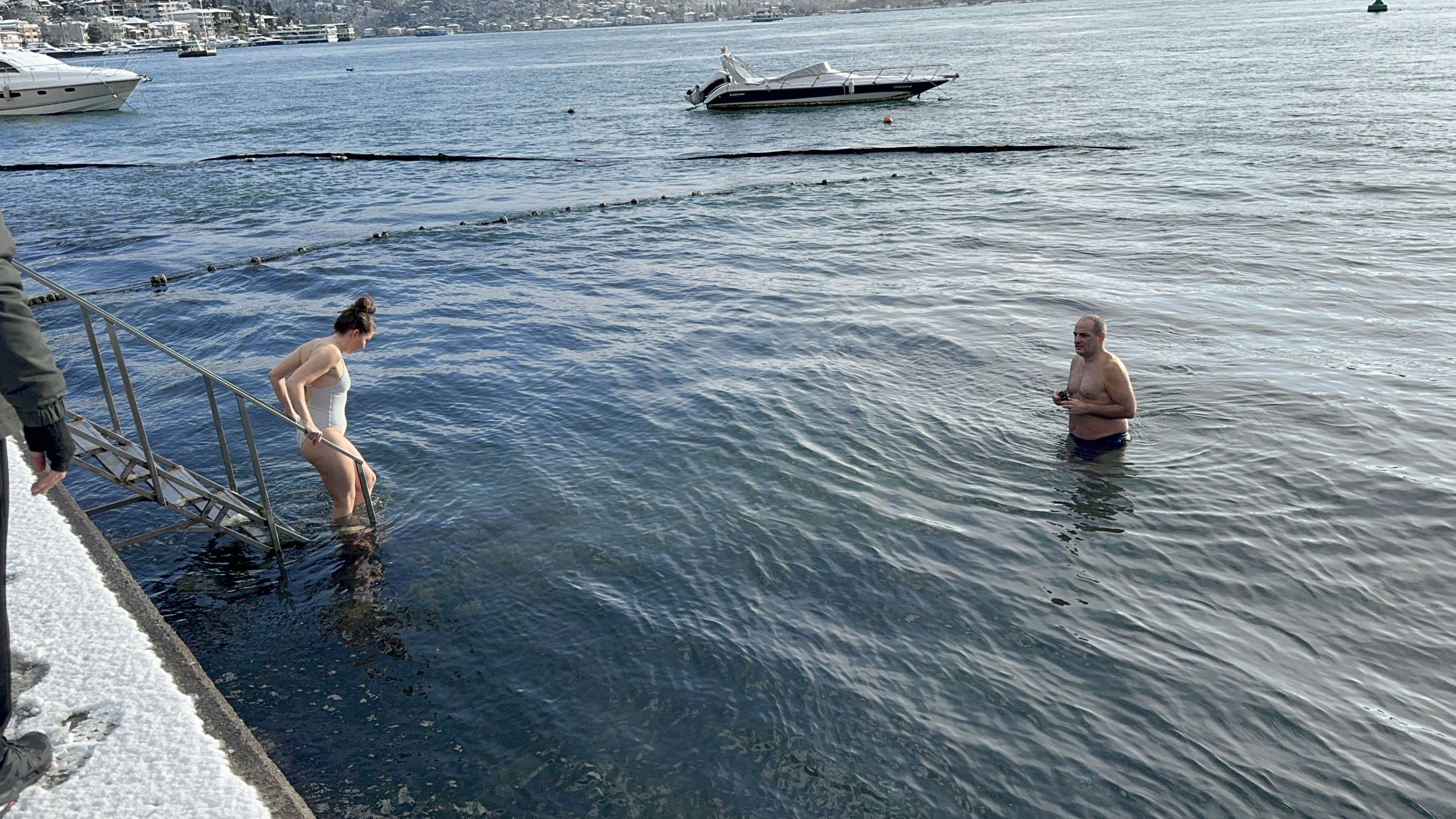 İstanbul Boğazı'nda bir grup insan karlı havada denize girdi