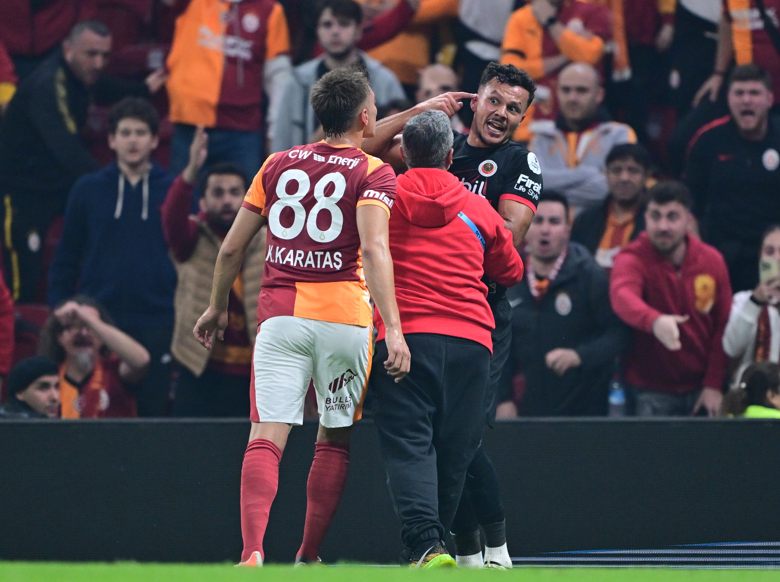 Deniz Çoban: Hakem Ozan Ergün’ün geçtiğimiz sezondan beri kart standardı bir türlü oturmadı. Dün de tutarsızdı. Bazı pozisyonlarda ciddi gözlem ve yorum eksikliği sahaya yansıdı. 31'de Talisson ile Kazımcan arasında yaşanan gerginlikte her iki oyuncuya gösterilen sarı kartlar yerindeydi. Ancak hakem, tansiyonun o noktaya gelmesine müsaade etmeyebilirdi.   49'da Barış Alper’in ortasında Talisson’un Barış'a topuğuyla yaptığı temas penaltı şüphesi doğurdu. Hakemin devam kararı bu açıdan bence doğruydu.   60'ta Talisson’un Kazımcan'a yaptığı kontrolsüz faulde ikinci sarı kart doğruydu. Ancak ikinci sarı kartın çıkacağı bir faulde avantaj oynatmak, avantaj kuralına aykırıydı. Hakem oyunu anında kesip kırmızı kartı göstermeliydi.  63’te Göktan’ın Sallai’ye yaptığı müdahale, futbol oyun kurallarında "kırmızı kart"la cezalandırılması gereken türdendi, acımasız ve rakibin sağlığını riske atan bir hareketti. Buna rağmen hakem kart dahi çıkarmadı. Bu durum, sadece maçın değil hakemlik kalitesinin de zedelendiğini gösteriyor.  90+4'te Sallai’ye VAR müdahalesiyle çıkan kırmızı kart doğruydu. Ozan Ergün bu maçta ciddi kart hataları yaptı. Kontrolsüzlük, avantaj kuralının yanlış uygulanışı ve kırmızı kart kriterlerinin göz ardı edilmesi, bu seviyede bir hakemden beklenmeyecek türdendi. (Fanatk)