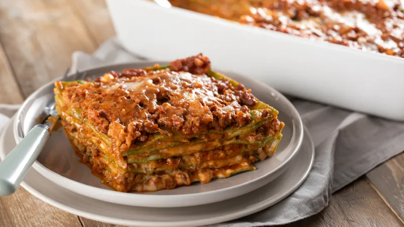 <p><strong>1. Lasagne alla Bolognese (İtalya)</strong></p> <p>Lasagne alla Bolognese, &ccedil;oğunlukla ıspanakla tatlandırılmış taze yumurtalı lazanya hamurunun kat kat dizilmesiyle hazırlanır. &Uuml;zerine beşamel sos ve rag&ugrave; alla Bolognese adı verilen yoğun bir et sosu eklenir. Son aşamada Emilia b&ouml;lgesinin &ldquo;peynirlerin kralı&rdquo; Parmigiano-Reggiano bolca serpilir ve fırında i&ccedil;i yumuşak, &uuml;st&uuml; ise &ccedil;ıtır ve kızarmış olana kadar pişirilir. Bu klasik fırın yemeği, &ouml;zellikle Bologna kentiyle &ouml;zdeşleşmiş Emilia-Romagna mutfağının tipik bir &ouml;rneğidir.</p>