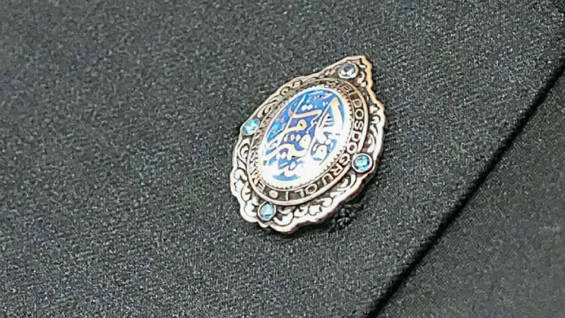 <p>Bah&ccedil;eli'nin&nbsp;&ouml;zel bir mine iş&ccedil;iliği ile renklendirilmiş rozetinde ise yine&nbsp;Hud Suresi 112. Ayet'in işlendiği g&ouml;r&uuml;ld&uuml;.</p>