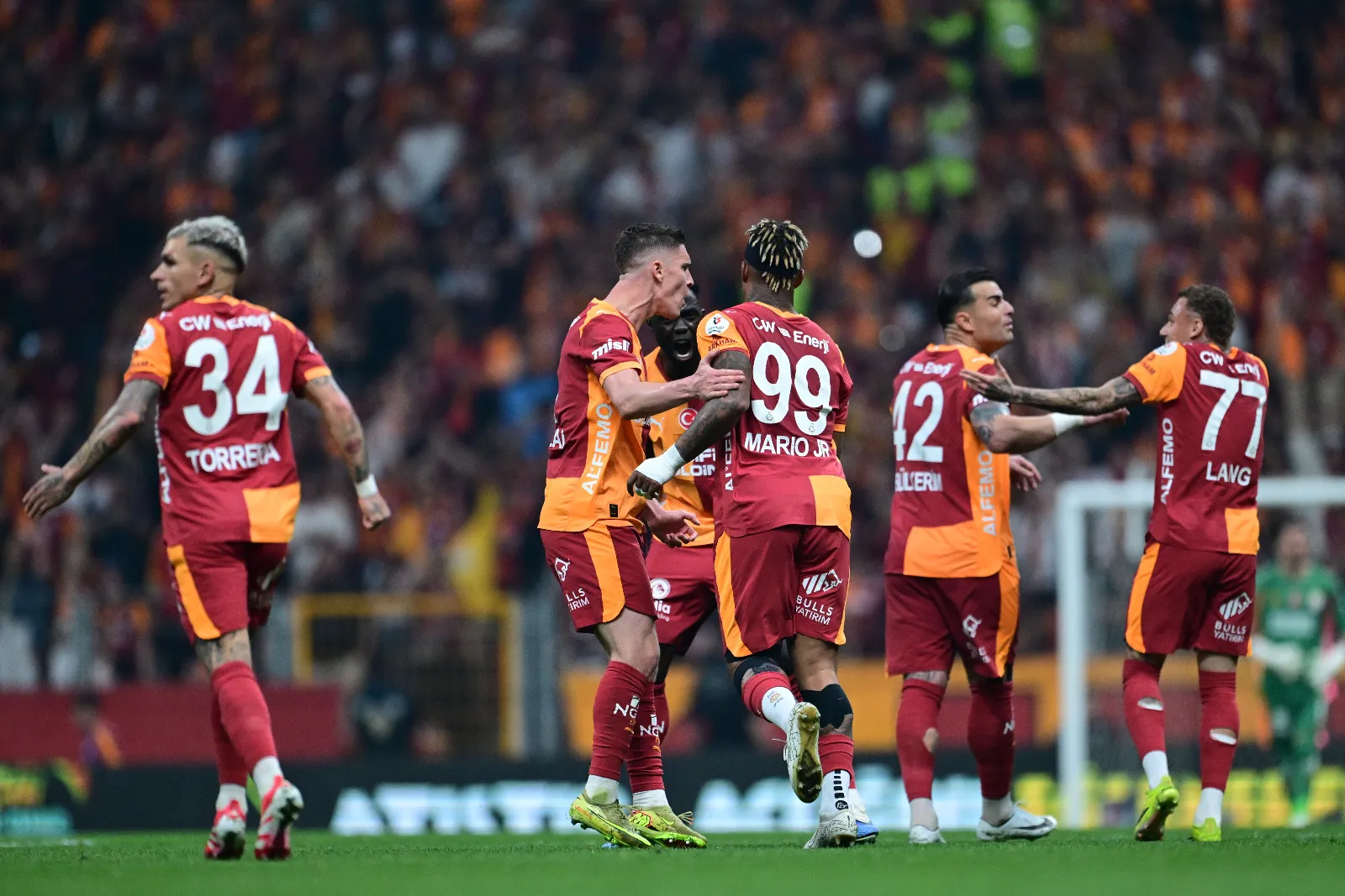 <p class="MsoNormal"><span style="mso-ansi-language: EN-GB;">Zeki Uzundurukan: &Uuml;st &uuml;ste d&ouml;rt yıldır 35 milyon Galatasaray taraftarına Binbir Gece Masalı gibi sezonlar yaşatıyorlar. Sanki suda s&ouml;nmeyen akşam g&uuml;neşi gibiydiler. Ana s&uuml;t&uuml; gibi helal bir şampiyonluk daha! Bu sezon da S&uuml;per Lig'de y&uuml;reklerin g&ouml;nderine yine Galatasaray bayrakları &ccedil;ekildi. G&ouml;ky&uuml;z&uuml; kırmızı; G&uuml;neş sarı... Altın alkışlar Galatasaray'a... Emek, alınteri ve takım b&uuml;t&uuml;nl&uuml;ğ&uuml;, camia b&uuml;t&uuml;nl&uuml;ğ&uuml; Galatasaray'ı bu sezon da mutlu sona ulaştırdı. G&ouml;zleri şampiyonluktan başka hi&ccedil;bir şey g&ouml;rmeyen futbolcular topluluğu: İşte Galatasaray!&nbsp;</span></p>
<p class="MsoNormal"><span style="mso-ansi-language: EN-GB;">Osimhen; iğne deliğinden fil ge&ccedil;iren adam! Barış Alper Yılmaz: Delikanlı yanını sevinciyle g&ouml;steren bir futbol beyfendisi! Gerektiğinde b&uuml;t&uuml;n takımı sırtında taşıdığı yetmezmiş gibi, attığı gollerden sonra omuzlarına &ccedil;ıkan takım arkadaşlarını taşıyan bir y&uuml;k treni! Torreira! Smokinle değil formayla sahaya &ccedil;ıkan bir iş&ccedil;i! Galatasaray trib&uuml;nlerini birleştiren bir atom karınca... Leroy Sane: Ayakları ile senfoni yazan bir futbol piyanisti. Yunus Akg&uuml;n: Ayakları ile resim &ccedil;izen futbol ressamı. İcardi: Tam bir futbol ve gol profes&ouml;r&uuml;. D&uuml;nk&uuml; şampiyonluk ma&ccedil;ında Kaan Ayhan'a attırdığı golde Messi'den kesitler sundu. Uğurcan &Ccedil;akır: Her ma&ccedil;ta arkadaşlarını sırtına aldı, karşıdan karşıya ge&ccedil;irdi. Formasının i&ccedil;ine y&uuml;reğini de koyan kaleci. Galatasaray'ın bu sezonki lig şampiyonluğunun KOD ADI ise 26! Eller alkışladı... Diller onayladı... Aslan Cimbom m&uuml;hr&uuml;n&uuml; bastı... ŞAMPİYON GALATASARAY!</span></p>