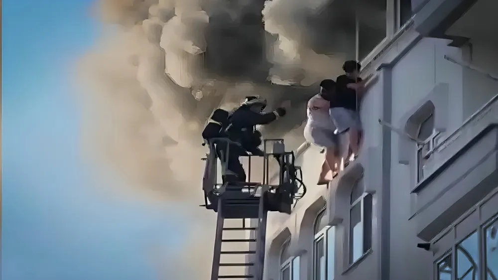 Yangından kaçmak için terastan sarkan gençler son anda kurtarıldı