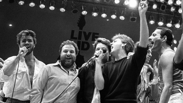 Michael (en solda), Live Aid konserinin Wembley Stadium'daki final performansında, yardım konserlerinin fikir babası Harvey Goldsmith (soldan ikinci) ile efsanevi sanatçılar Bono, Paul McCartney, Bob Geldof ve Freddie Mercury ile birarada.